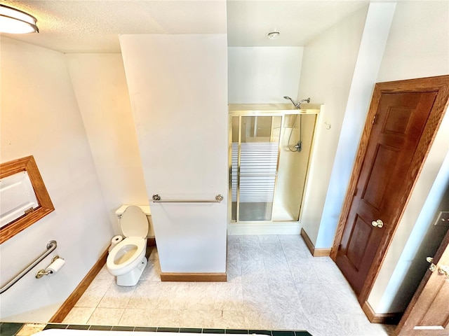 bathroom featuring a textured ceiling, toilet, baseboards, tile patterned floors, and a stall shower