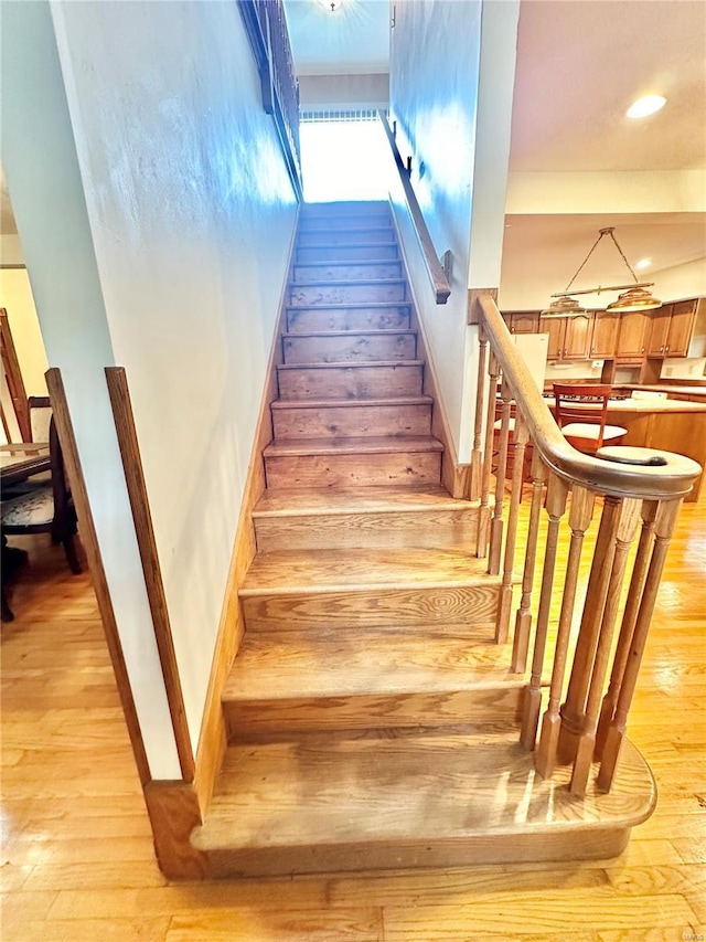 stairway with recessed lighting, baseboards, and wood finished floors