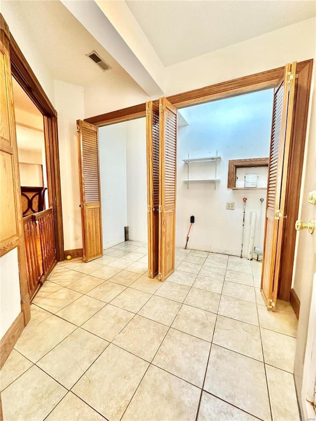 hall with visible vents and light tile patterned flooring