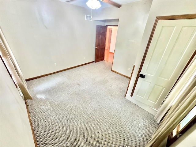 unfurnished bedroom featuring baseboards, visible vents, a ceiling fan, and light colored carpet