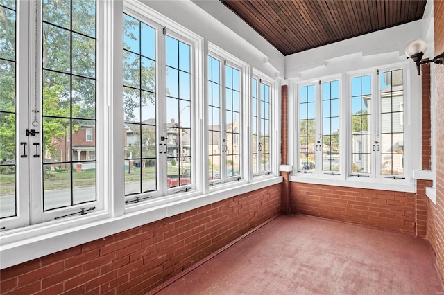 unfurnished sunroom with a healthy amount of sunlight and wooden ceiling