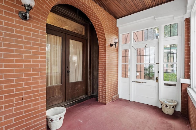 view of exterior entry with covered porch and french doors