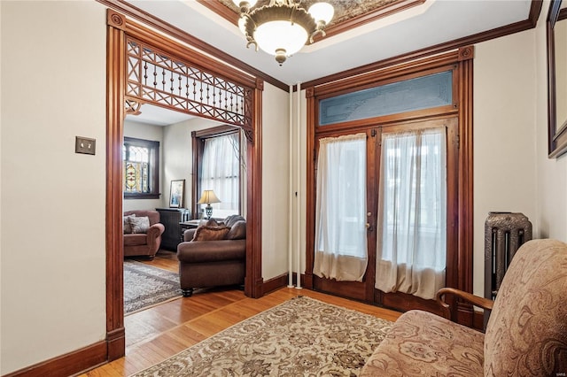 entryway with crown molding and light hardwood / wood-style flooring