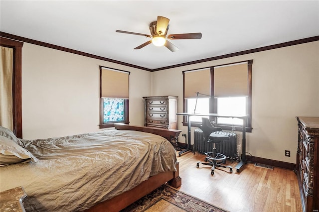 bedroom featuring ceiling fan, light hardwood / wood-style flooring, ornamental molding, and radiator heating unit