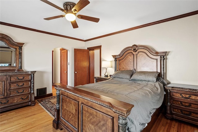 bedroom with hardwood / wood-style floors, ceiling fan, and ornamental molding