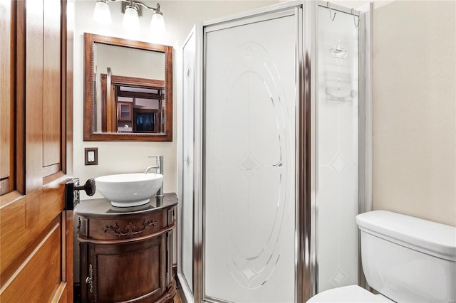 bathroom featuring toilet, vanity, and walk in shower