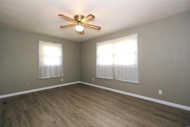 spare room featuring dark wood-type flooring and ceiling fan