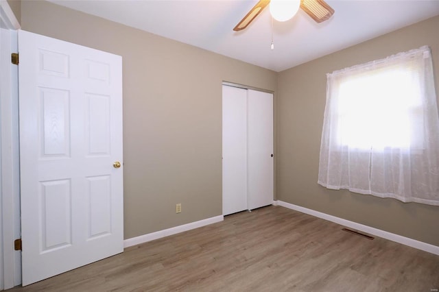 unfurnished bedroom with a closet, ceiling fan, and light hardwood / wood-style floors