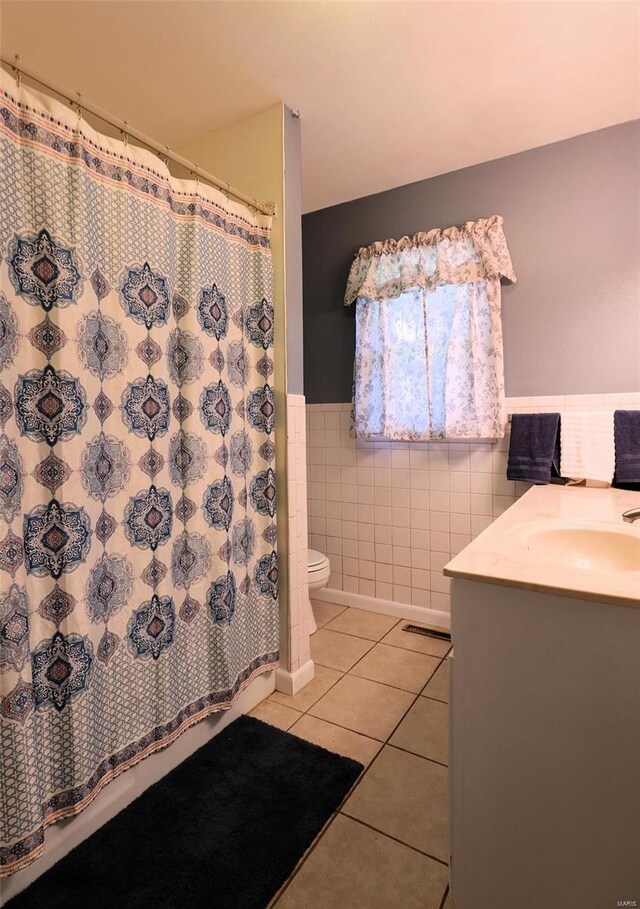 bathroom featuring vanity, toilet, tile walls, and tile patterned floors