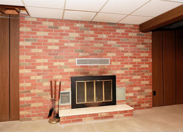 details featuring a fireplace, concrete floors, and a paneled ceiling