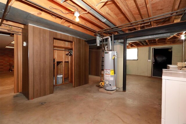 basement featuring washer and clothes dryer and water heater