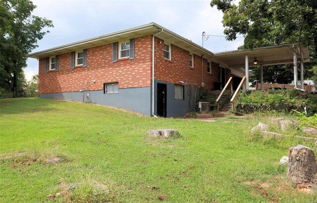 back of property featuring a lawn and central air condition unit