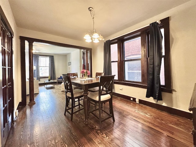 dining room featuring ceiling fan with notable chandelier, ornate columns, and dark hardwood / wood-style floors