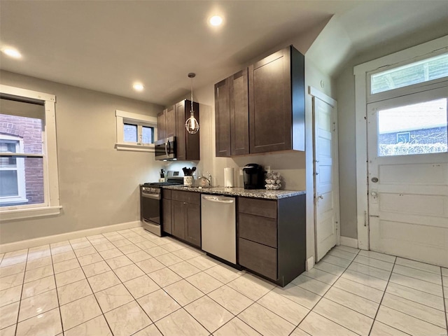 kitchen featuring stainless steel appliances, dark brown cabinetry, light tile patterned floors, and hanging light fixtures