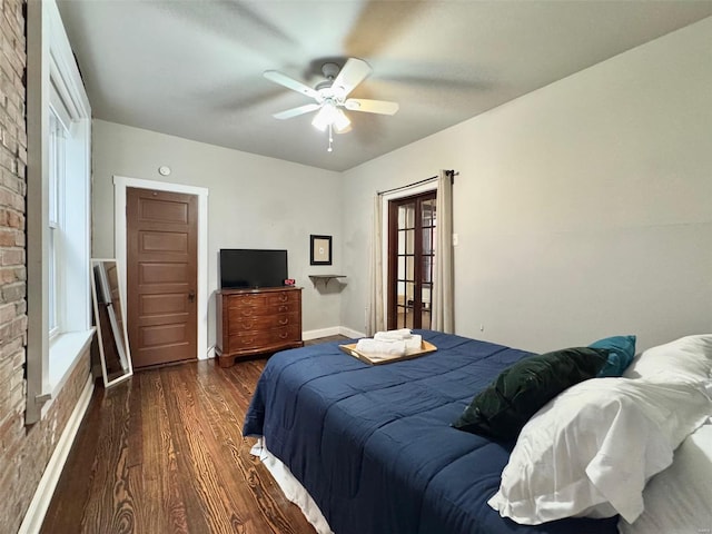 bedroom with ceiling fan, brick wall, dark hardwood / wood-style flooring, and multiple windows