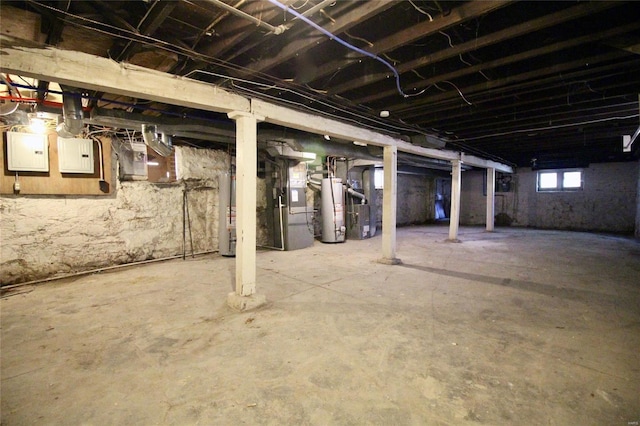 basement featuring gas water heater, electric panel, and heating unit