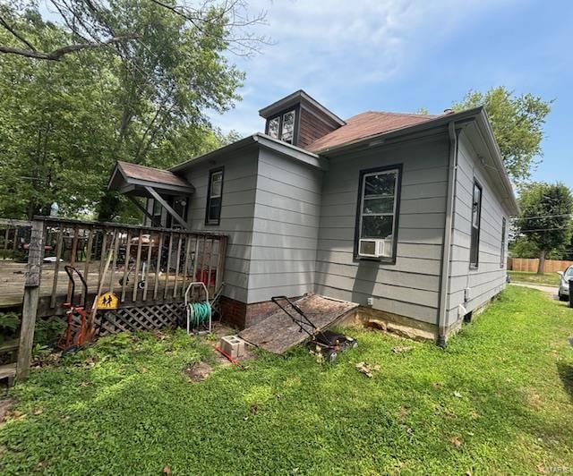 view of home's exterior featuring cooling unit, a deck, and a yard