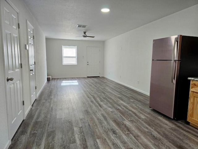 interior space featuring a textured ceiling, dark wood-type flooring, and ceiling fan