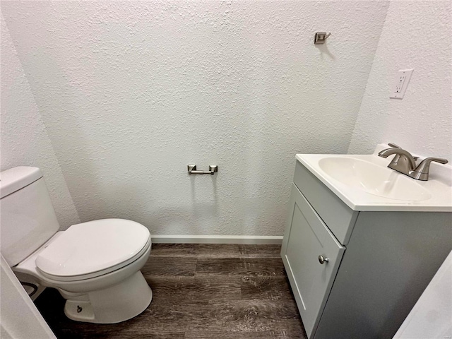 bathroom featuring toilet, vanity, and hardwood / wood-style floors