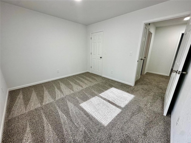 unfurnished bedroom with dark carpet