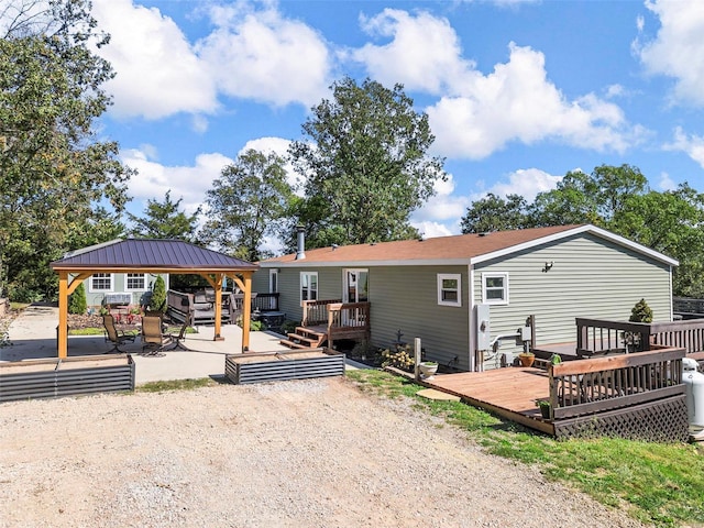 rear view of property with a wooden deck and a gazebo