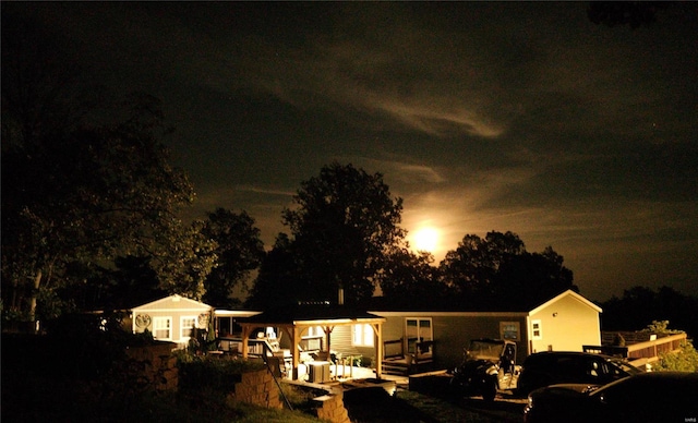 back of house at twilight featuring a wooden deck