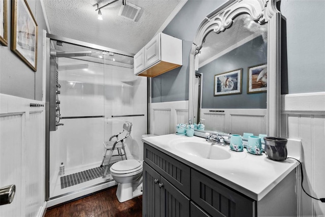 bathroom featuring a shower stall, a textured ceiling, visible vents, and wood finished floors