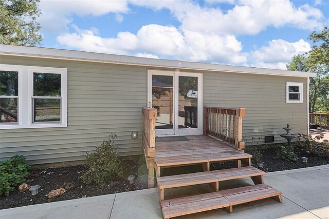 entrance to property with crawl space and a wooden deck