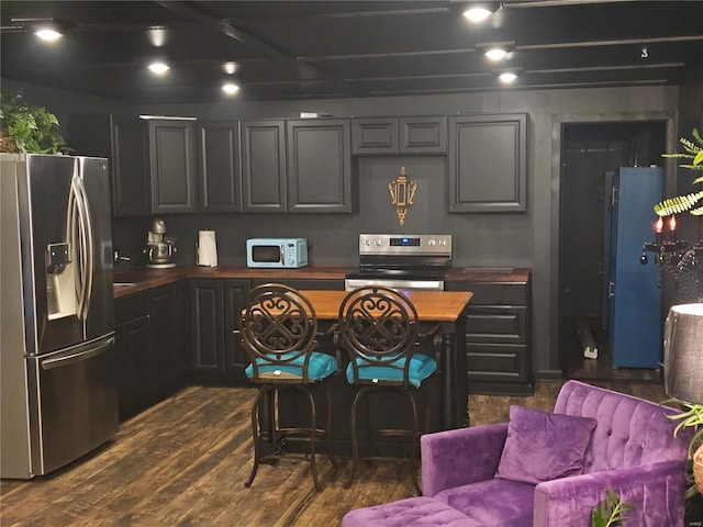 kitchen with appliances with stainless steel finishes and dark wood-style flooring