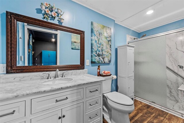 bathroom with toilet, a stall shower, wood finished floors, and vanity