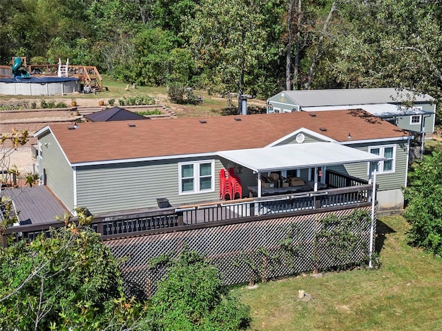 back of property featuring a lawn and a wooden deck