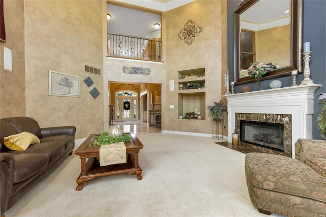 living room featuring visible vents, carpet floors, ornamental molding, and a high end fireplace