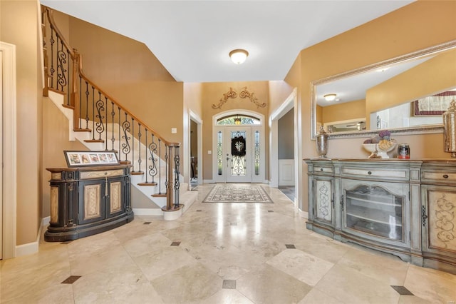 entrance foyer featuring stairway and baseboards