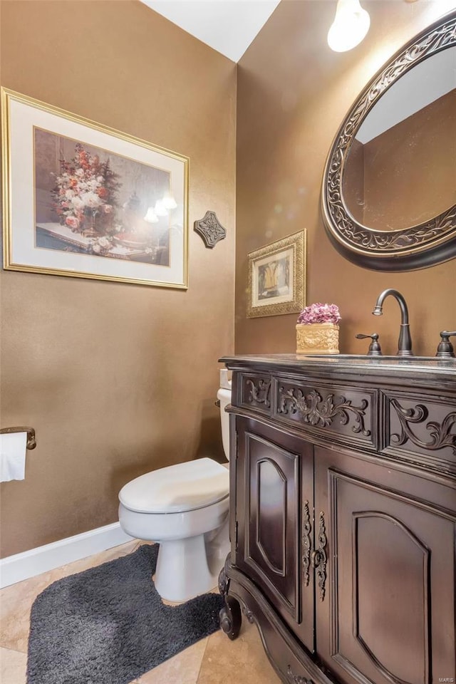 bathroom with toilet, tile patterned flooring, vanity, and baseboards