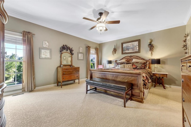 carpeted bedroom featuring ornamental molding, visible vents, baseboards, and a ceiling fan