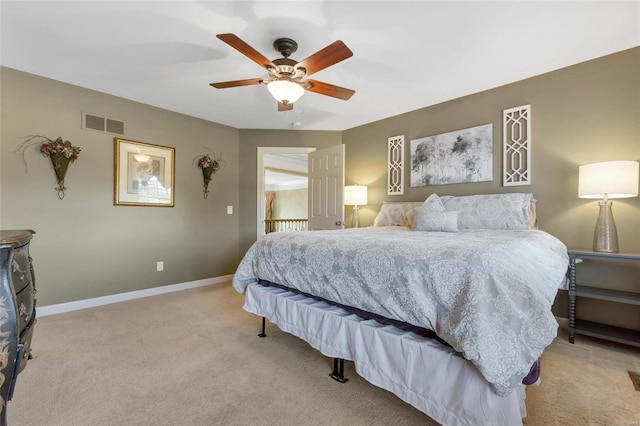 bedroom with light carpet, ceiling fan, visible vents, and baseboards