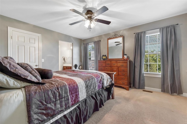 bedroom with light carpet, ceiling fan, multiple windows, and baseboards