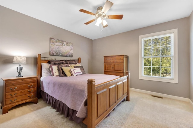 bedroom featuring light carpet, a ceiling fan, visible vents, and baseboards