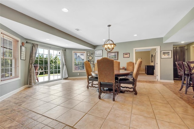 dining area with light tile patterned floors, visible vents, a chandelier, and baseboards