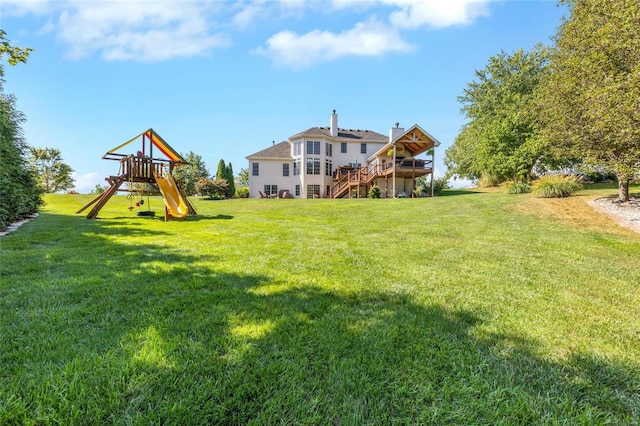 view of yard with a deck, stairway, and a playground