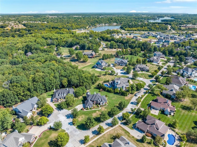 birds eye view of property with a forest view, a water view, and a residential view