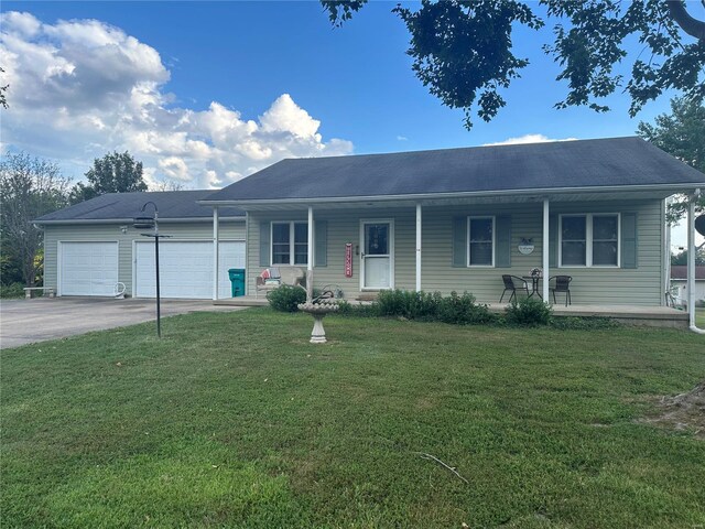 ranch-style home featuring a garage, covered porch, concrete driveway, and a front lawn