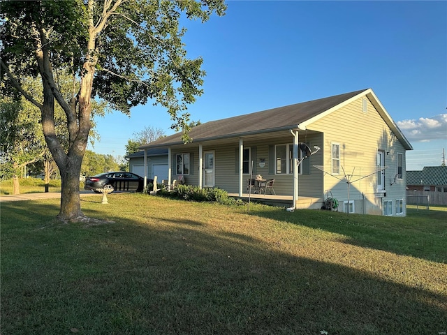 view of front of property featuring a front yard, covered porch, and a garage