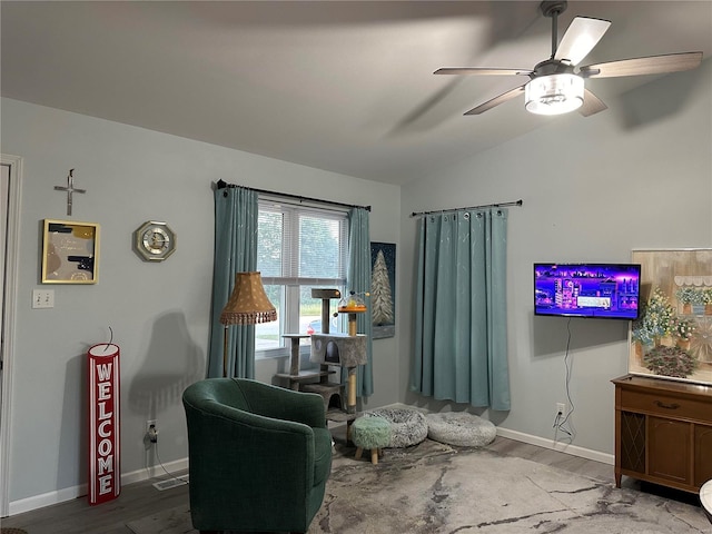 living area featuring baseboards, wood finished floors, a ceiling fan, and vaulted ceiling