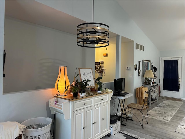 interior space featuring light wood-type flooring, visible vents, an inviting chandelier, and vaulted ceiling
