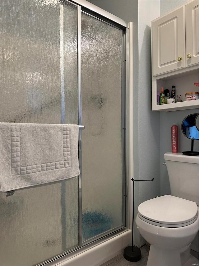 full bathroom featuring toilet and a stall shower
