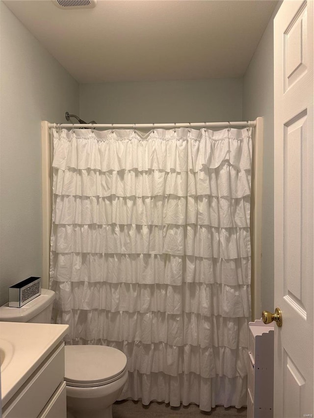 bathroom featuring a shower with curtain, toilet, visible vents, and vanity
