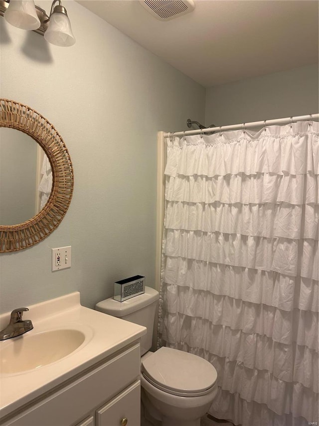 full bath featuring a shower with shower curtain, visible vents, toilet, and vanity