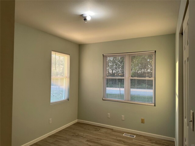 unfurnished room with hardwood / wood-style flooring