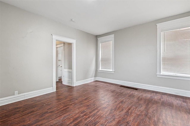 unfurnished room with dark hardwood / wood-style floors and plenty of natural light